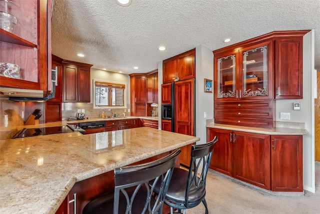 kitchen featuring reddish brown cabinets, black electric stovetop, a sink, and recessed lighting