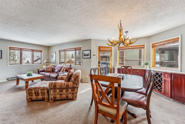 dining room featuring a chandelier, baseboards, a textured ceiling, and light colored carpet