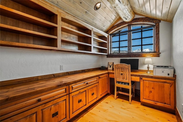 unfurnished office with built in desk, lofted ceiling with beams, light wood-type flooring, and wood ceiling