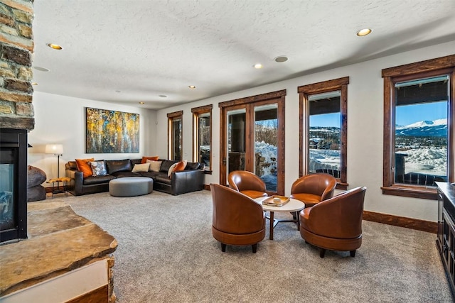 living room with a textured ceiling, carpet, and a fireplace