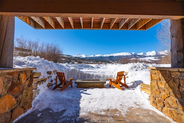 snow covered patio with a mountain view