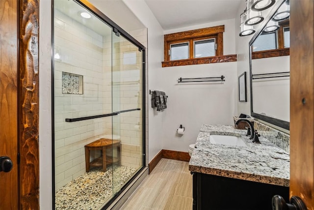 bathroom with walk in shower, vanity, and toilet