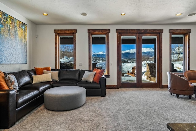 living room featuring a wealth of natural light, a textured ceiling, and carpet flooring