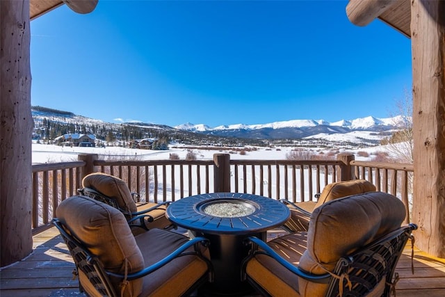 snow covered deck featuring a mountain view