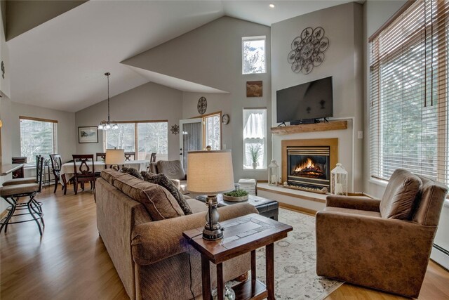 116 Blue Grouse Ln, Silverthorne, CO 80498 - living area featuring high vaulted ceiling, a glass covered fireplace, light wood finished floors, a chandelier, and recessed lighting