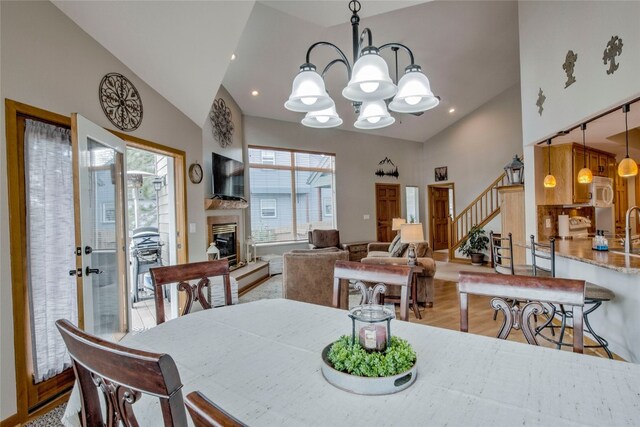 116 Blue Grouse Ln, Silverthorne, CO 80498 - dining space with plenty of natural light, a chandelier, stairway, light wood-type flooring, and high vaulted ceiling