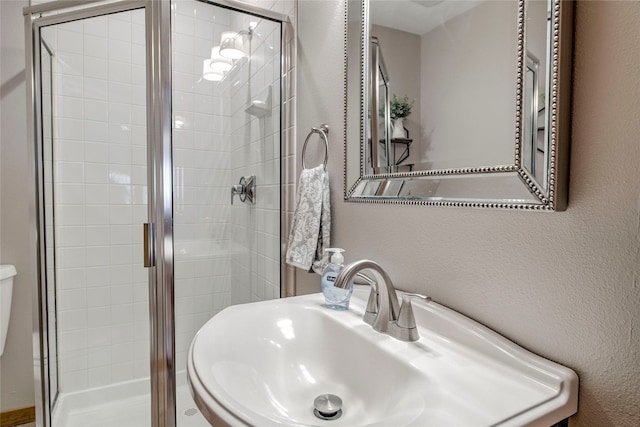 116 Blue Grouse Ln, Silverthorne, CO 80498 - bathroom with a shower stall, a textured wall, and a sink