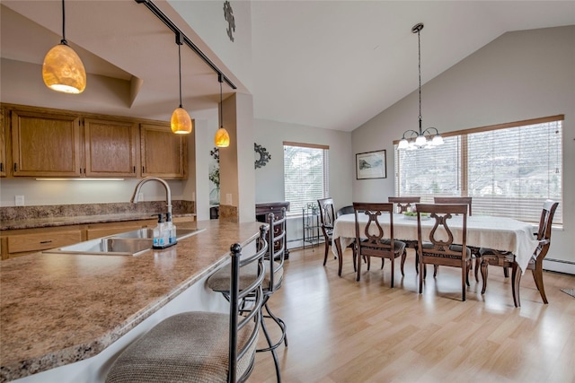 116 Blue Grouse Ln, Silverthorne, CO 80498 - kitchen featuring a sink, light wood-style flooring, a chandelier, hanging light fixtures, and high vaulted ceiling