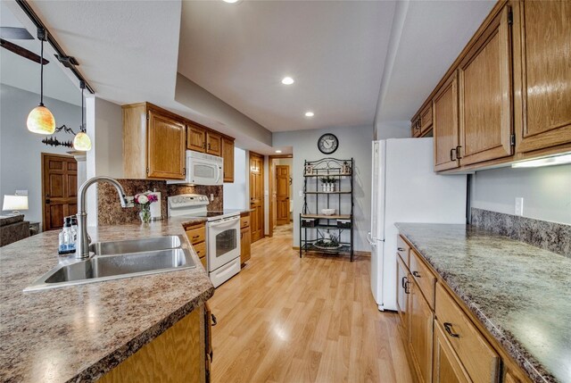 116 Blue Grouse Ln, Silverthorne, CO 80498 - kitchen featuring white appliances, a sink, light wood-style flooring, brown cabinets, and recessed lighting