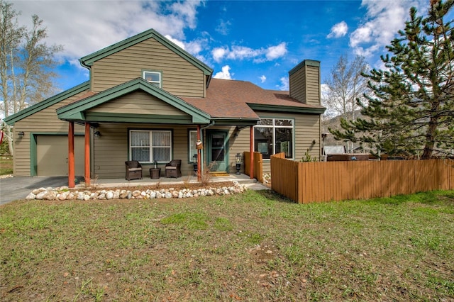 116 Blue Grouse Ln, Silverthorne, CO 80498 - back of property with a porch, a chimney, an attached garage, asphalt driveway, and a shingled roof