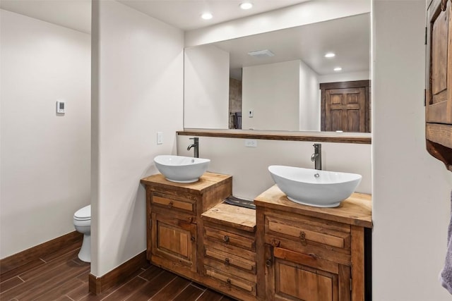 44 Maverick Way, Silverthorne, CO 80498 - bathroom featuring wood finished floors, double vanity, toilet, recessed lighting, and baseboards
