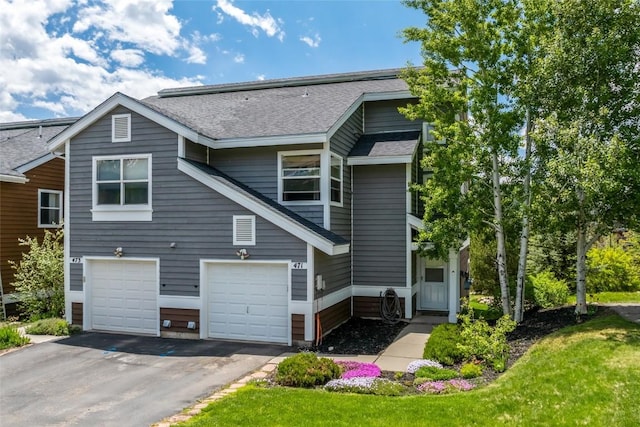 471 Mountain Vista Cir Unit 1, Steamboat Springs, CO 80487 - rear view of house featuring a shingled roof, driveway, and an attached garage