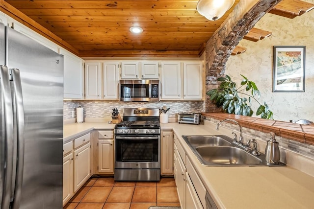 471 Mountain Vista Cir Unit 1, Steamboat Springs, CO 80487 - kitchen featuring stainless steel appliances, wooden ceiling, light countertops, decorative backsplash, and light tile patterned floors
