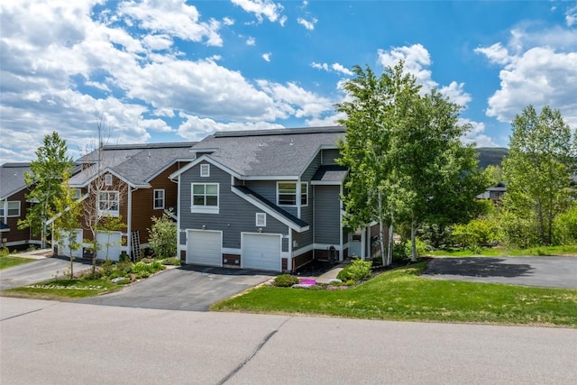 471 Mountain Vista Cir Unit 1, Steamboat Springs, CO 80487 - view of front facade with driveway, a garage, a front yard, and roof with shingles