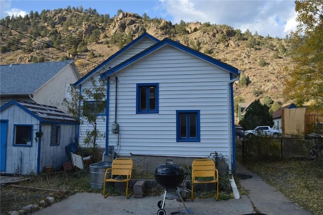215 Colorado Blvd, Idaho Springs, CO 80452 - rear view of property with fence, a storage shed, a mountain view, and an outbuilding