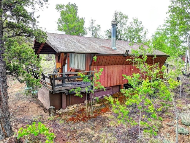 back of house with roof with shingles
