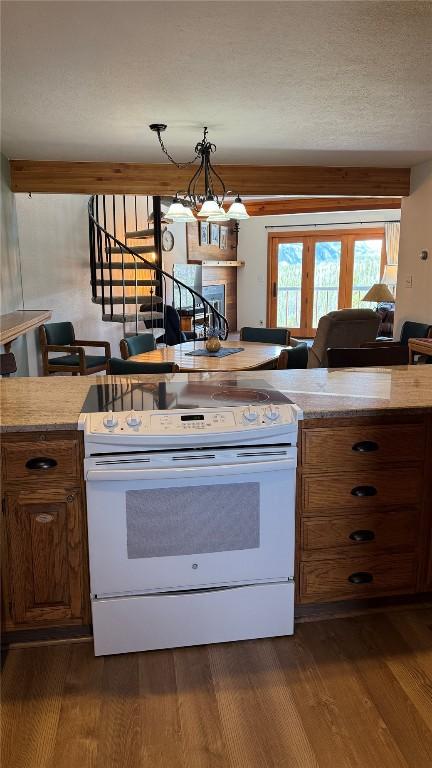 9430 Ryan Gulch Rd Unit 9453, Silverthorne, CO 80498 - kitchen with electric stove, brown cabinets, dark wood-style floors, and light countertops