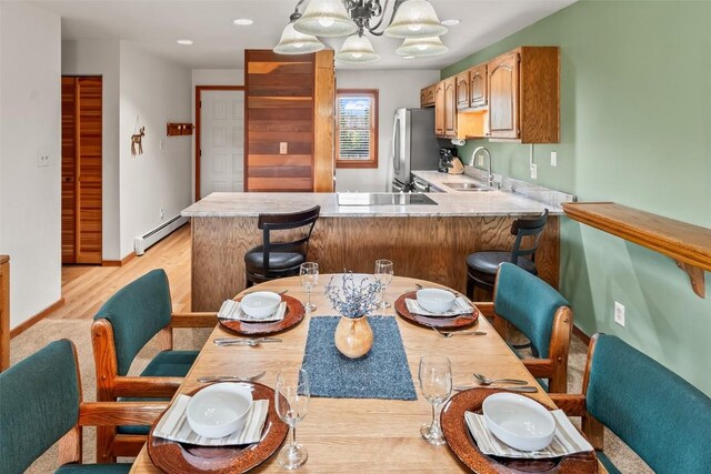 9430 Ryan Gulch Rd Unit 9453, Silverthorne, CO 80498 - kitchen featuring a sink, a baseboard heating unit, freestanding refrigerator, a peninsula, and light countertops