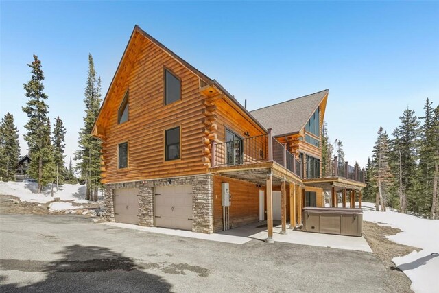 306 Robertson Ln, Breckenridge, CO 80424 - view of side of property featuring log siding, a garage, stone siding, a hot tub, and a balcony