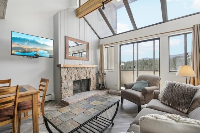 living room with a baseboard radiator, a stone fireplace, a high ceiling, and a mountain view