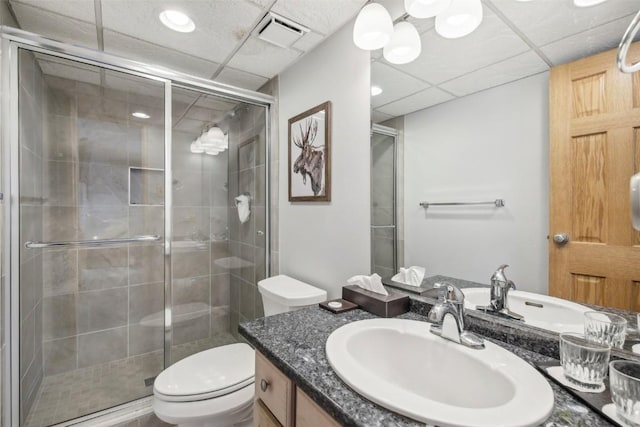 full bathroom featuring a drop ceiling, visible vents, toilet, vanity, and a stall shower