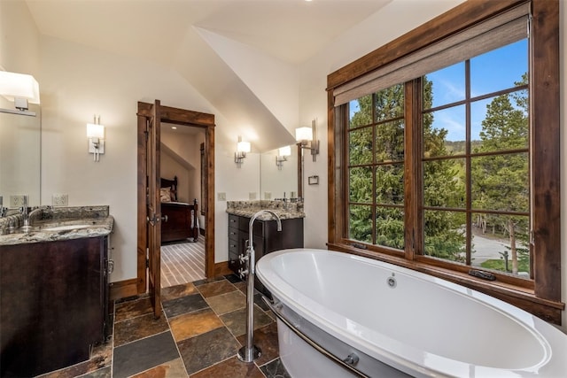 215 Royal Tiger Rd, Breckenridge, CO 80424 - bathroom featuring a soaking tub, two vanities, and stone tile flooring