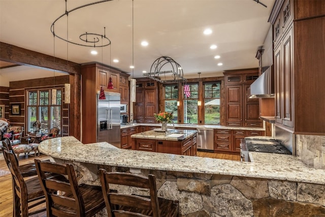 215 Royal Tiger Rd, Breckenridge, CO 80424 - kitchen with appliances with stainless steel finishes, wall chimney exhaust hood, light stone countertops, light wood-style floors, and recessed lighting