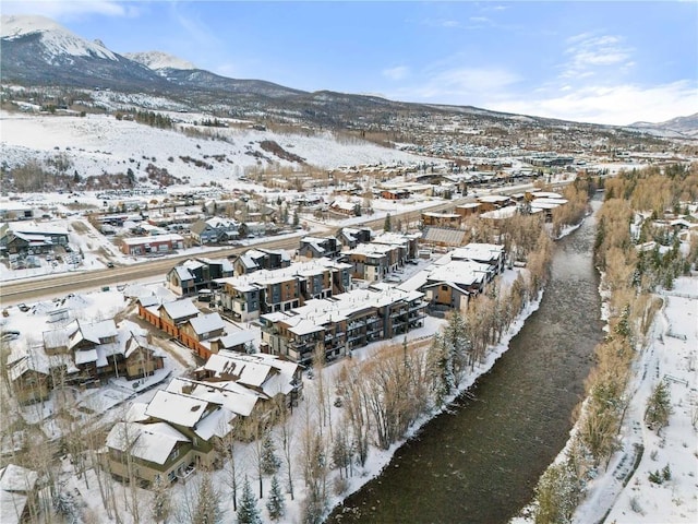 snowy aerial view with a residential view and a mountain view