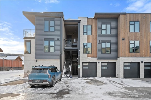 townhome / multi-family property with an attached garage, a balcony, and stairway