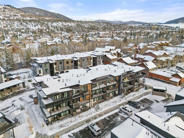 snowy aerial view featuring a mountain view and a residential view