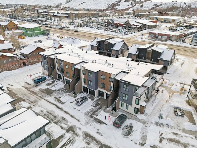 snowy aerial view with a residential view and a mountain view
