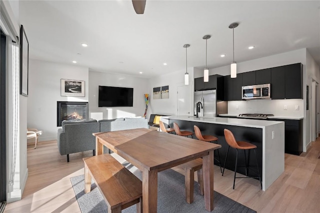 dining area with light wood-style floors and recessed lighting