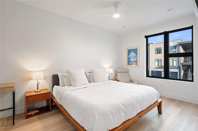 bedroom with ceiling fan, baseboards, and wood finished floors