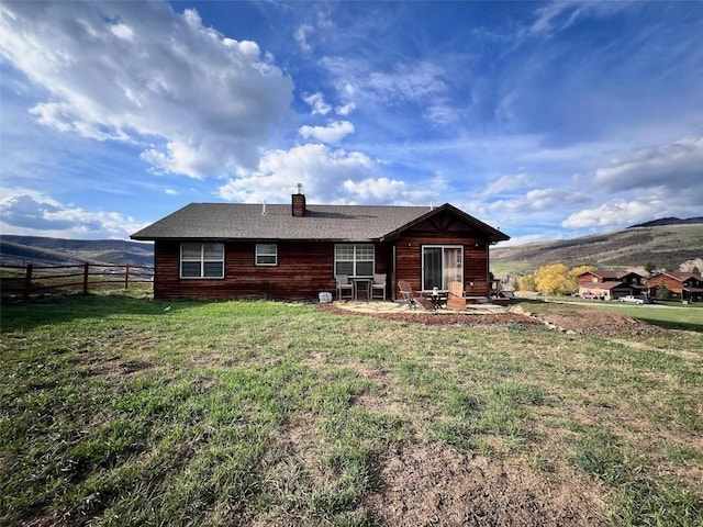 158 Oak Ridge Cir, Oak Creek, CO 80467 - back of house featuring a chimney, a mountain view, and a patio area