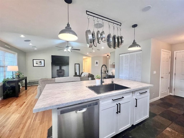 158 Oak Ridge Cir, Oak Creek, CO 80467 - kitchen featuring stainless steel dishwasher, a sink, white cabinets, light countertops, and open floor plan
