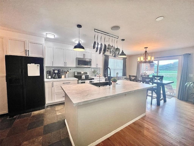 158 Oak Ridge Cir, Oak Creek, CO 80467 - kitchen with appliances with stainless steel finishes, a sink, white cabinetry, light countertops, and a chandelier