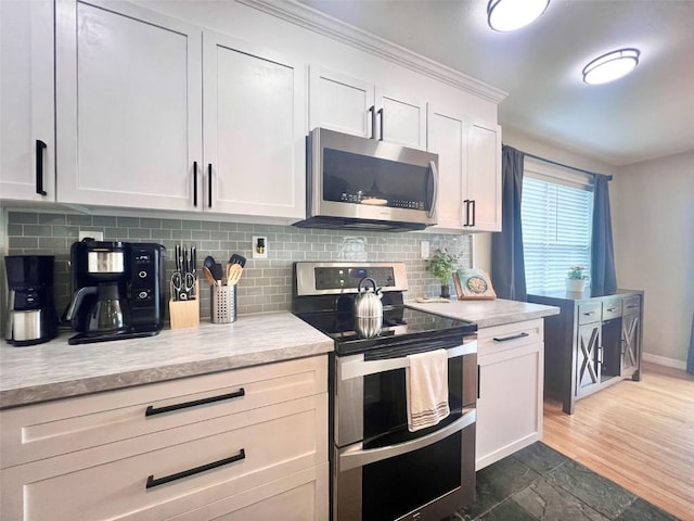 158 Oak Ridge Cir, Oak Creek, CO 80467 - kitchen featuring stainless steel appliances, light countertops, tasteful backsplash, and white cabinets