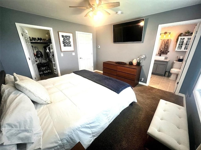 158 Oak Ridge Cir, Oak Creek, CO 80467 - carpeted bedroom with a closet, ensuite bathroom, a walk in closet, a ceiling fan, and baseboards