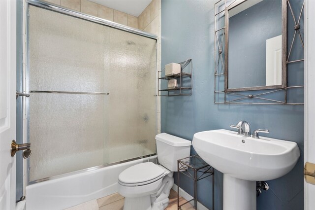 481 Marmot Cir, Silverthorne, CO 80498 - bathroom featuring toilet, combined bath / shower with glass door, a sink, and tile patterned floors