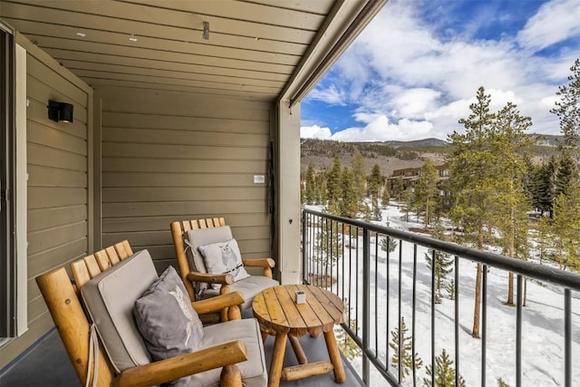 snow covered back of property featuring a mountain view