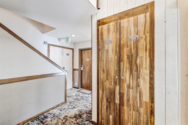 corridor featuring light carpet and stairs