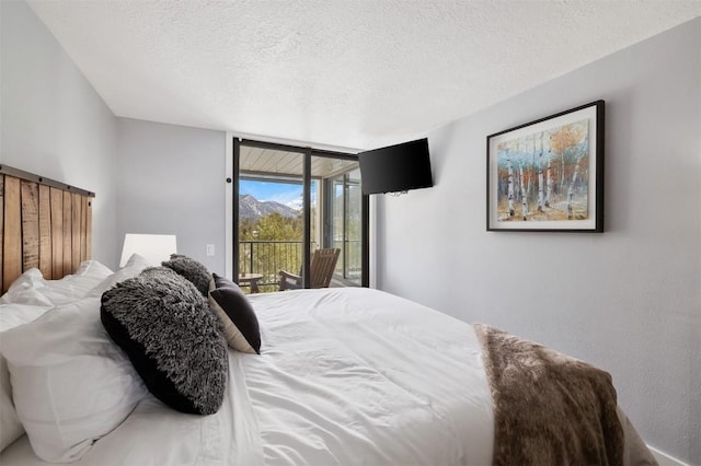 bedroom with expansive windows, a textured ceiling, and access to exterior
