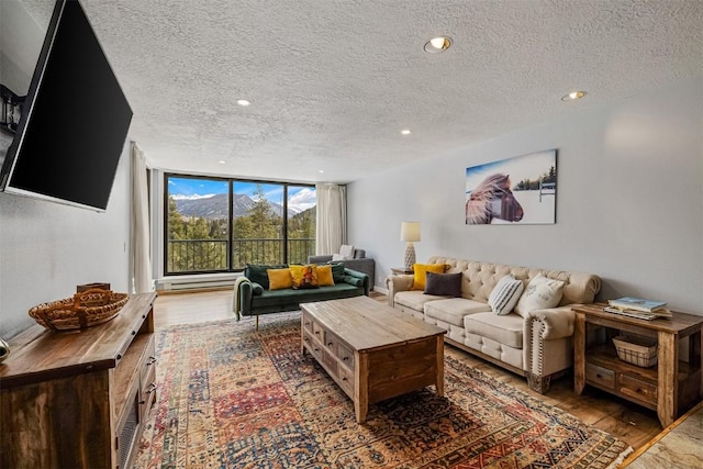 living room with wood finished floors, a textured ceiling, and recessed lighting