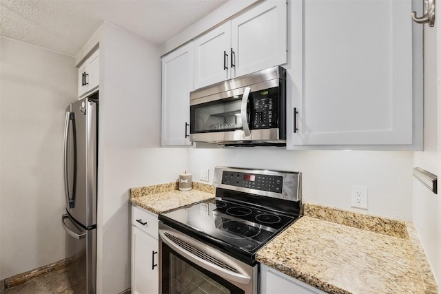 kitchen featuring light stone countertops, white cabinetry, and stainless steel appliances