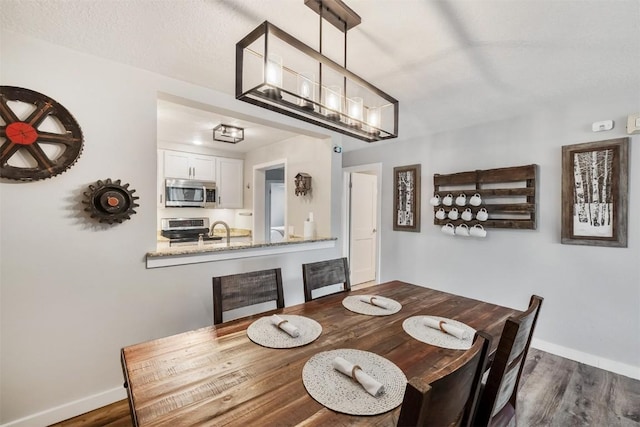 dining space with baseboards and dark wood-style flooring