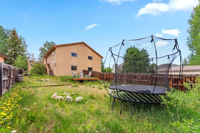 336 N Chipmunk Cir, Silverthorne, CO 80498 - fenced backyard featuring a trampoline, a deck, and stairway