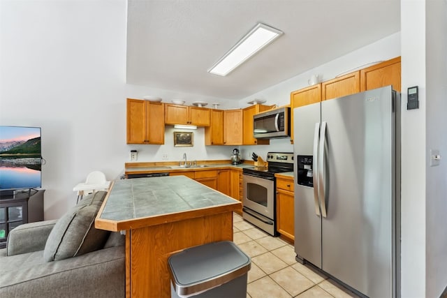 336 N Chipmunk Cir, Silverthorne, CO 80498 - kitchen with appliances with stainless steel finishes, light tile patterned floors, a kitchen bar, open floor plan, and tile counters