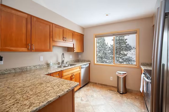 723 Meadow Creek Dr Unit B, Frisco, CO 80443 - kitchen with a sink, appliances with stainless steel finishes, light stone counters, brown cabinets, and baseboards