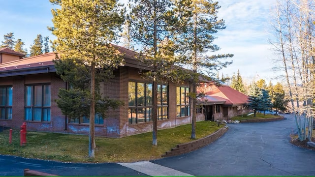 723 Meadow Creek Dr Unit B, Frisco, CO 80443 - view of property exterior with brick siding and a yard