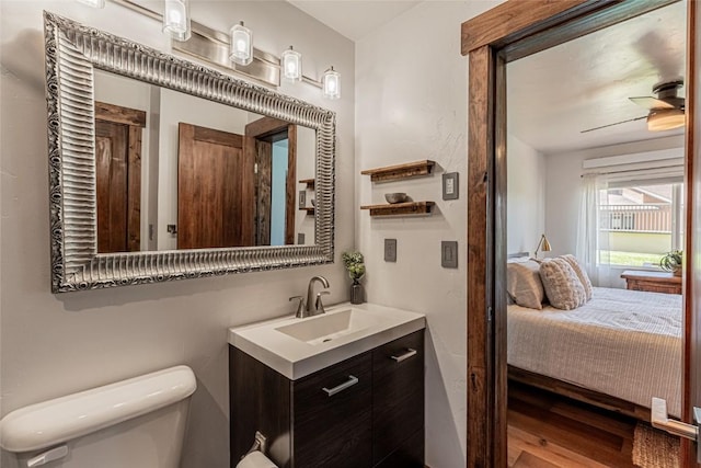 2235 Storm Meadows Dr Unit 312, Steamboat Springs, CO 80477 - half bathroom featuring toilet, vanity, wood finished floors, ensuite bathroom, and ceiling fan